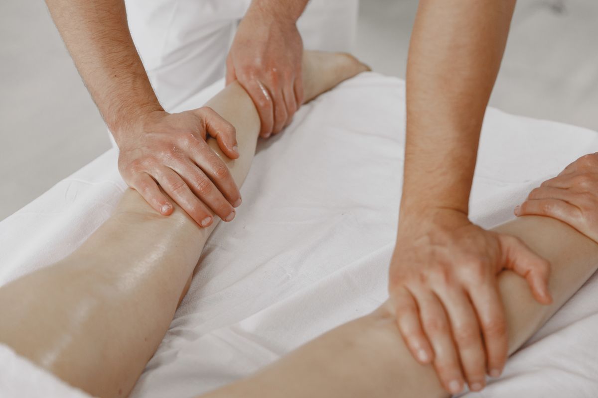 Mains effectuant un massage des jambes — photo d’illustration